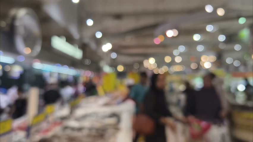 Blurred indoor shot of crowded shopping mall hallway during weekend holiday sale activity.