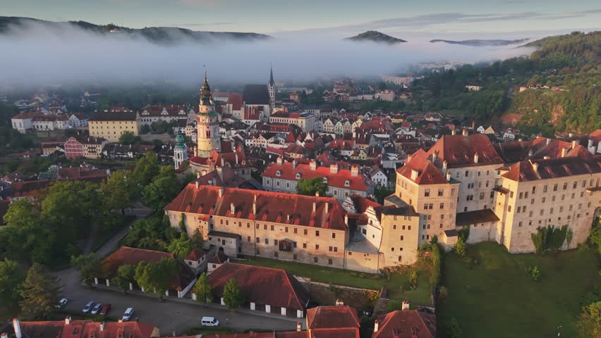 Aerial view of Cesky Krumlov castle in morning fog, famous fairytale town in Czech Republic. Cesky Krumlov ancient architecture in fog, picturesque travel landmark in Czechia