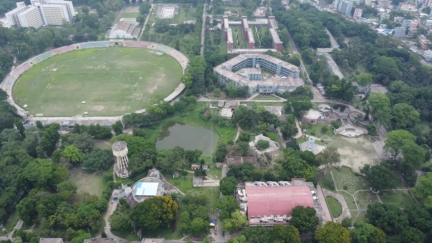 Aerial view of a stadium and academic buildings surrounded by parkland and trees drone sports field building campus drone sports field building campus