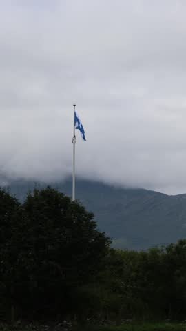Scottish Saltire Flag Flying with Mountain Landscape in the Highlands of Scotland
