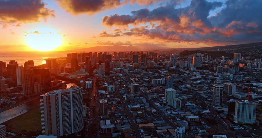 Amazing sunset above the panorama of Honolulu, Hawaii, USA. Colorful cumulus clouds in the sky over the city.