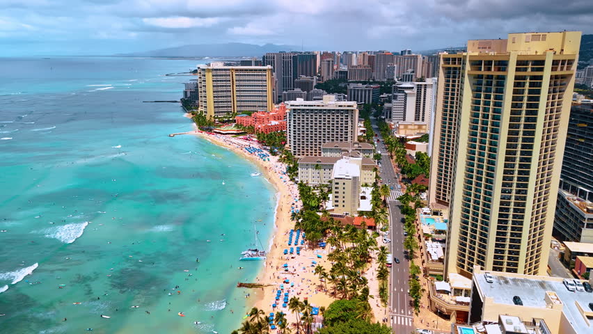 Fantastic scenery of sandy beach and urban area of Waikiki resort. Drone footage above the waterscape of the Pacific Ocean. Honolulu, Hawaii, USA.