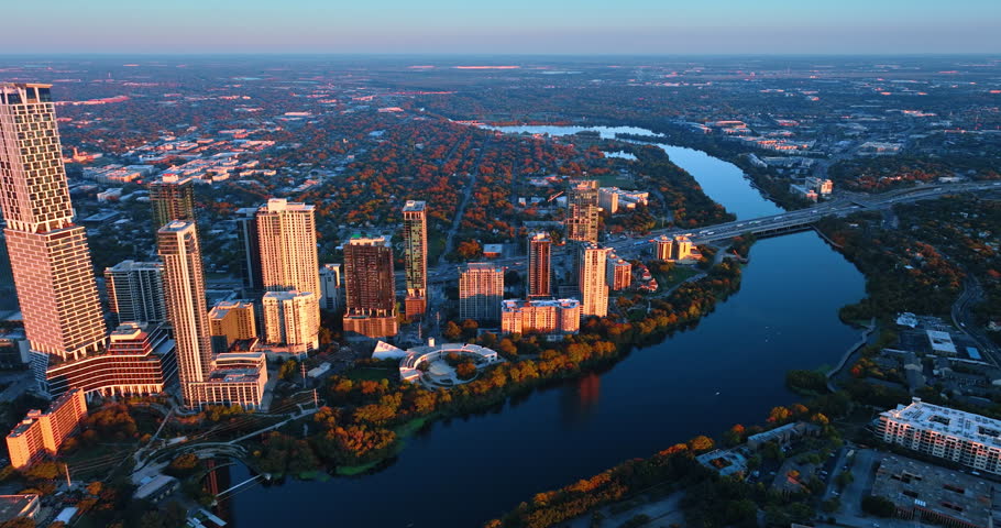 High-rises of Austin downtown lit with light of setting sun. Panorama of the beautiful city from drone.