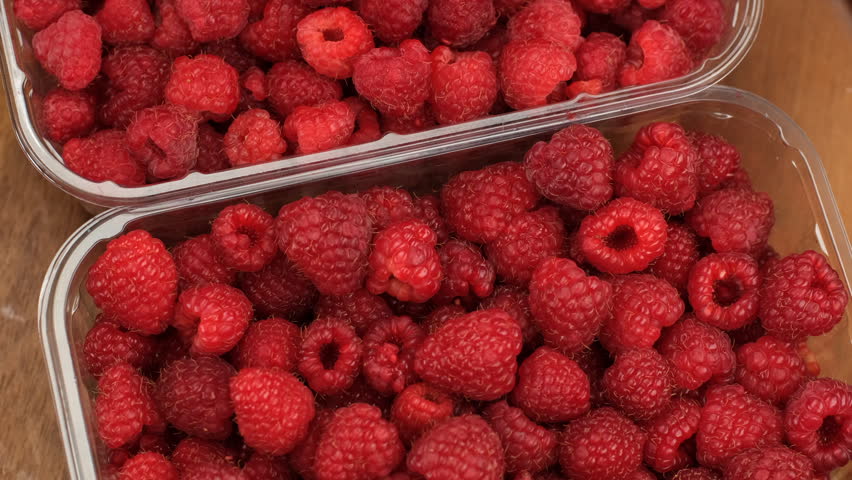 Fresh raspberries in plastic boxes in the supermarket