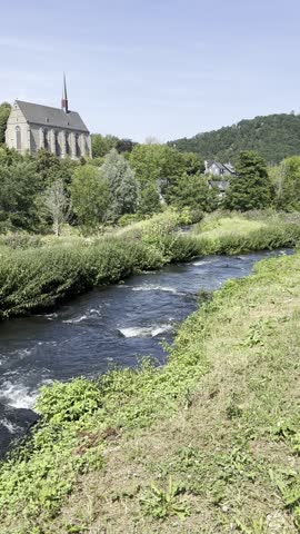 Wupper river with traditional slate farmhouse and forested hills near Beyenburg, Wuppertal, Germany