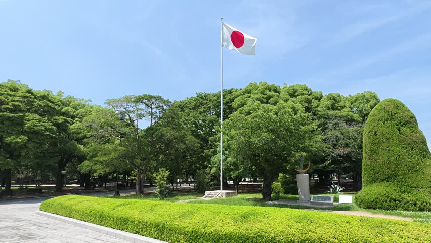 Japanese flag waving in a peaceful memorial park