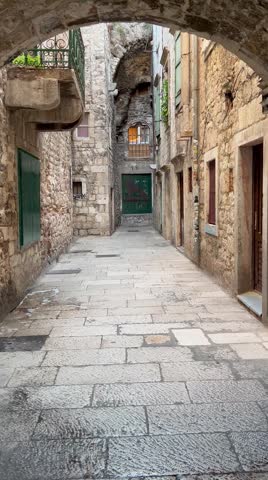 Old narrow stone street passing through an arched tunnel in the historical centre of Split, Dalmatia, Croatia