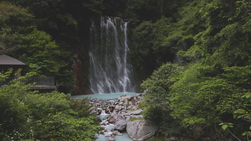Milky white water flows down Mauro Falls and mountain stream in Kirishima, Japan