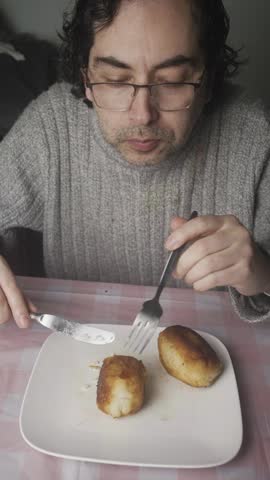 Medium Close Up Shot of Man Cutting and Eating Stuffed Potato