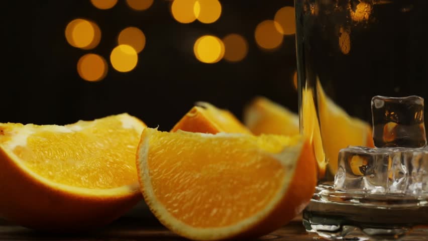 Black background and table with orange slices and glass of orange juice