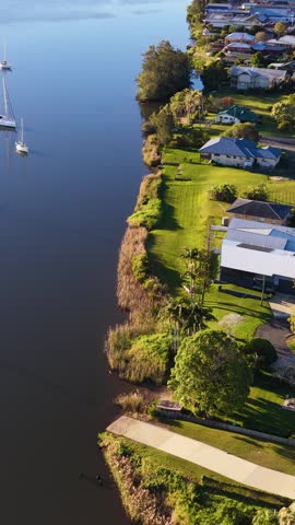 High angle drone shot of suburban homes along the Clarence River in Maclean, Australia.