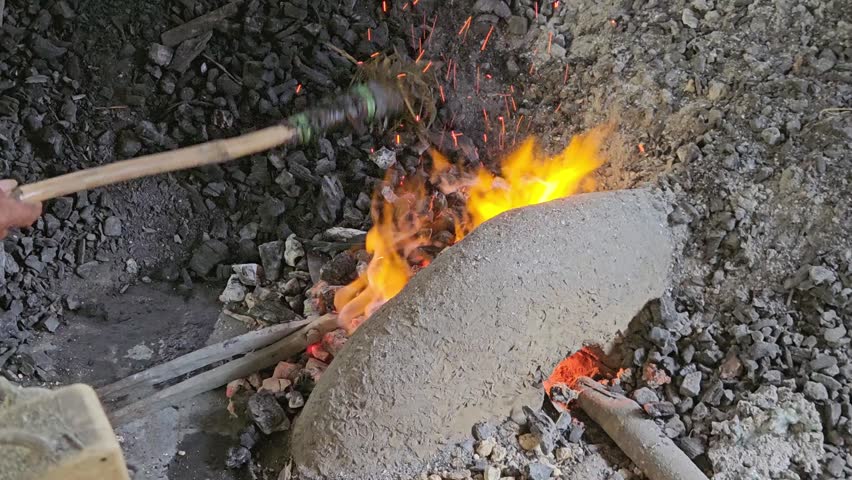 Central Java, August 3, 2026. A traditional blacksmith is shown forging metal. Glowing red steel is held with tongs against an anvil, highlighting the intense heat and the skill involved in manually shaping the metal. This image is ideal for editorial use, articles on traditional craftsmanship, the metal industry, manufacturing, and local culture, as well as content themed around hard work and expertise.
