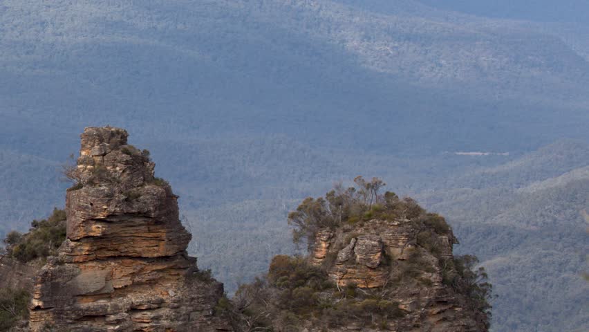 Static telephoto shot of the Three Sisters sandstone peaks in Katoomba, New South Wales, Australia.
