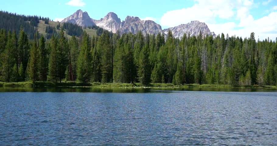 Sawtooth Mountain peaks emerging from alpine lake and forest in Idaho