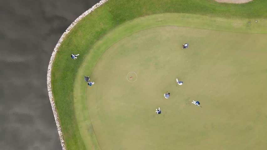 Cinematic aerial drone footage of a beautiful golf course with lush green fairways and golfers playing. Stunning aerial landscape ideal for sports, luxury lifestyle, tourism, resort, recreation, and corporate projects.