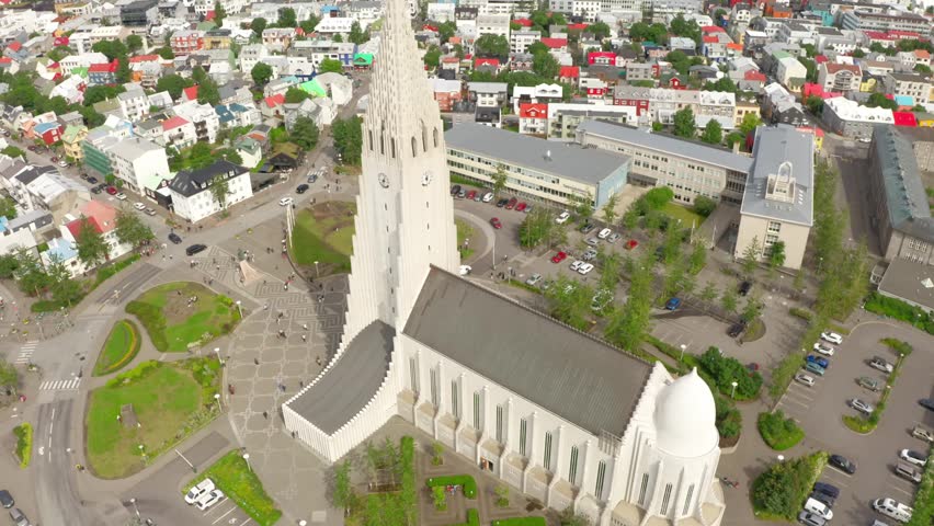 Aerial drone footage flying over Hallgrímskirkja church, revealing the colorful cityscape and architecture of downtown Reykjavik, Iceland.