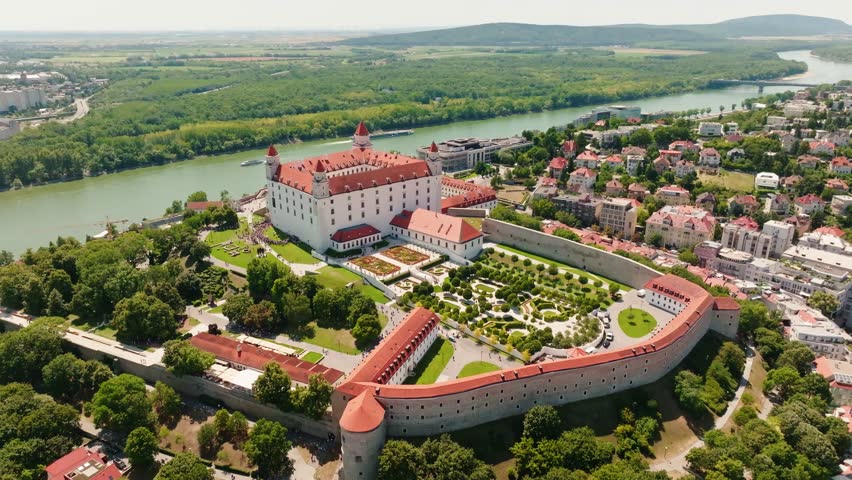 Cinematic aerial drone view of Bratislava Castle, its historic gardens and the Danube River. Stunning panorama of one of Slovakia