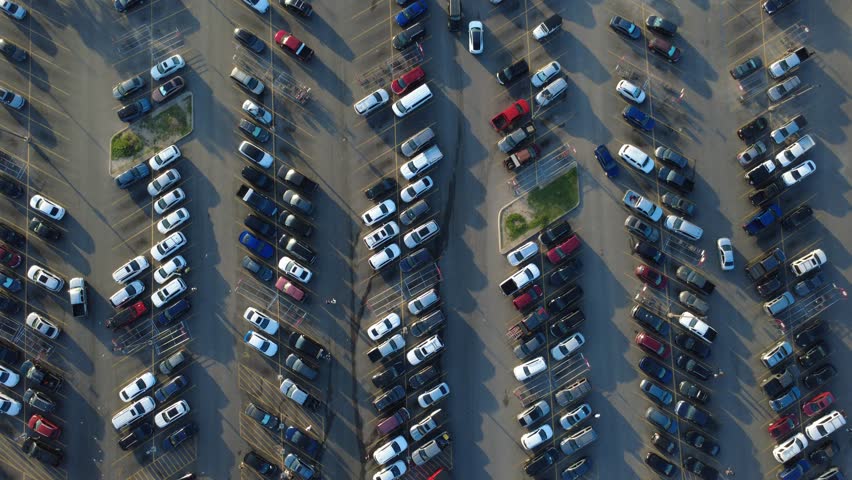 Marked parking stalls frame active driving lanes at crowded Far Westside grocery center near Potranco Road. Pedestrians push shopping carts toward entrance doors, San Antonio, Texas. USA