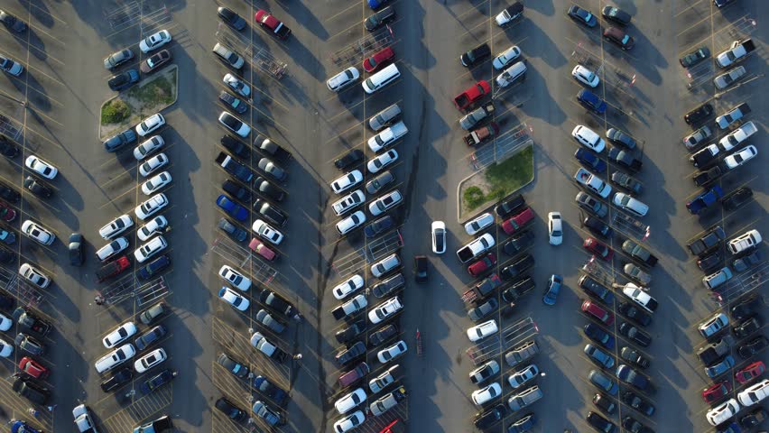Commuter automobiles fill orderly parking bays in Bexar County near Potranco Road during peak shopping hours. Continuous vehicle movement highlights supermarket venue, San Antonio, Texas. USA
