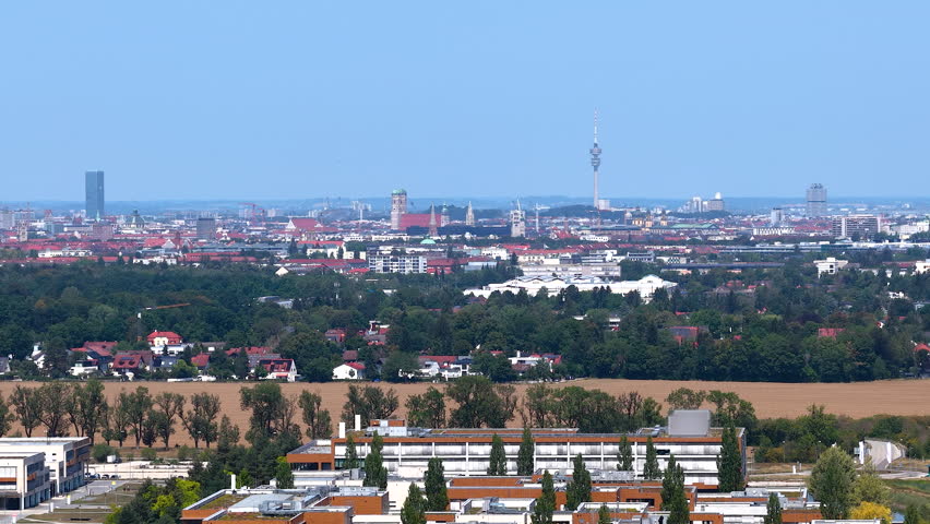 Aerial view of the Munich skyline from a distance featuring the Frauenkirche, Olympic Tower, St. Peter