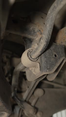 An old worn stabilizer bar bushing is mounted on a car.