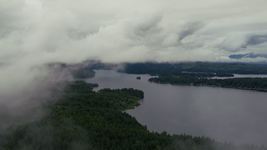 Low clouds drift over forested Sproat Lake shoreline near Port Alberni on a misty day