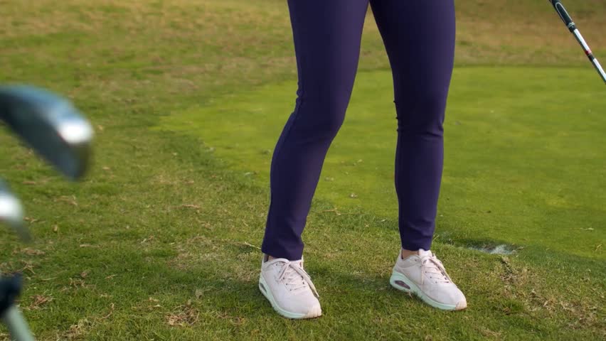 Golfer stands confidently on the tee, ready to take a swing. Bright green grass surrounds, highlighting the sport
