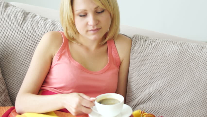 Girl resting on the couch and drinking coffee
