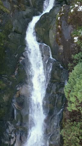 Majestic Waterfall Cascading Through Lush Green Forest in British Columbia, Canada
