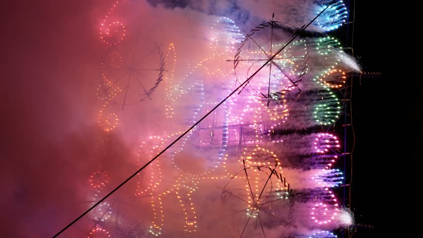 Traditional Mexican fireworks castle (castillo de pirotecnia) featuring spinning pyrotechnic wheels, glowing lights, smoke, and colorful sparks during a nighttime cultural celebration. Spectacular display of Mexican pyrotechnic craftsmanship and festive tradition.
