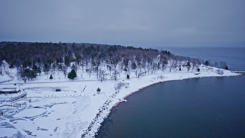 Panning drone shot looking out at breakwater on lake superior in Marquette Michigan