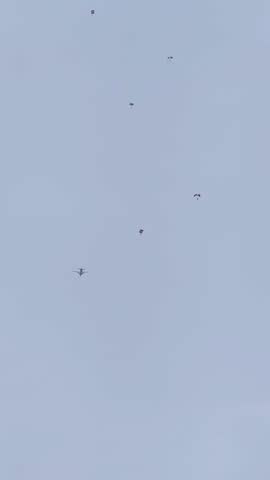 Video of turboprop airplane dropping Sky diver in a clear blue sky.