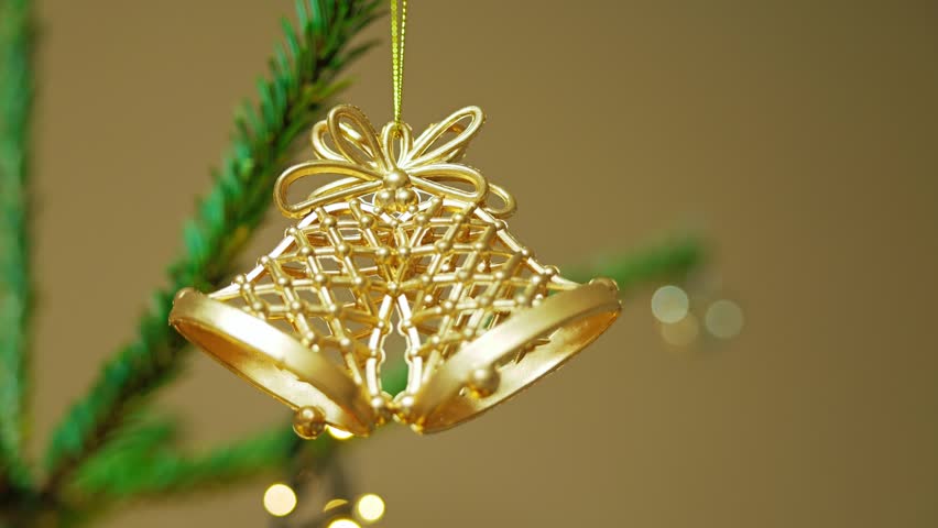 Camera slowly moves toward Christmas bells, festive lights twinkle softly behind