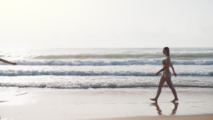 Smiling couple embracing on a tropical beach after running into each other