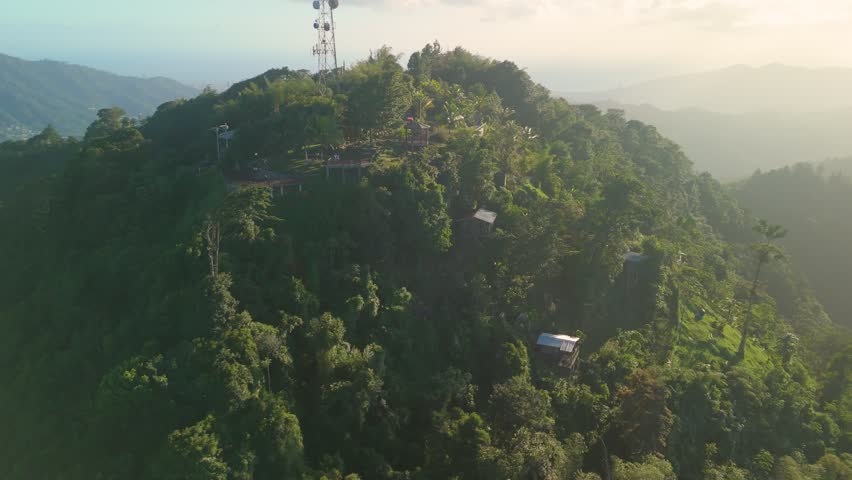 Aerial orbit shot circles La Vigie Paramin Lookout showing wooden viewing decks and panoramic mountain coastline views in Trinidad