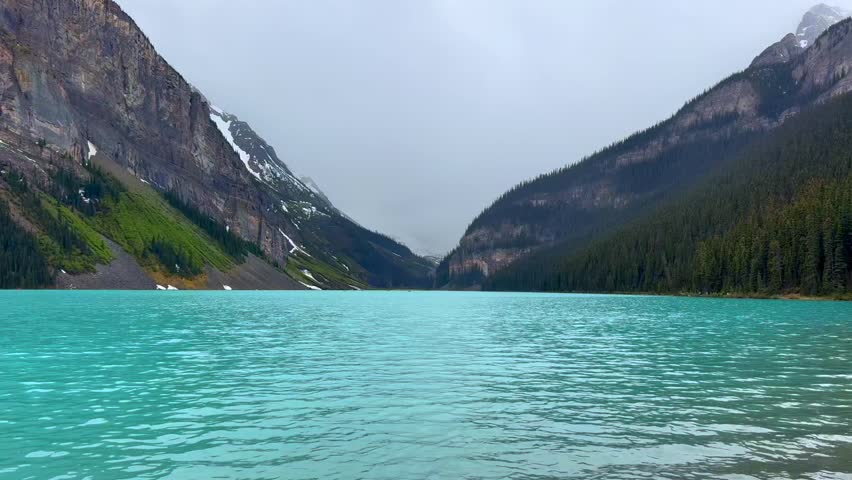 Beautiful view on the Lake Louise in National Park of Banff, Canada. Stunning view of a turquoise lake surrounded by majestic mountains and evergreen trees, showcasing the natural beauty of the landscape