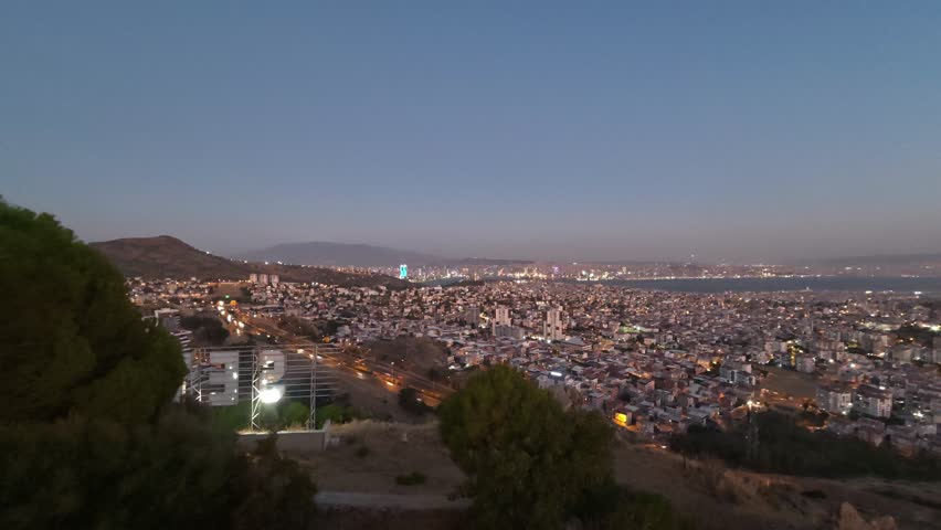 Timelapse video capturing the Moon rising above a city skyline, showcasing the transition from dusk to night and the beauty of the urban night sky.