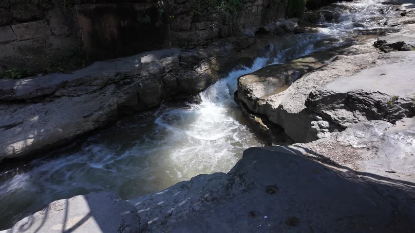 Rushing water flows through rocky landscape in a stream
