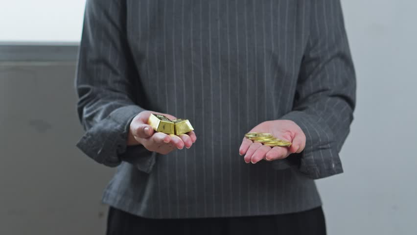 Woman holds gold bars in one hand and bitcoin coins in the other for comparing traditional and digital assets