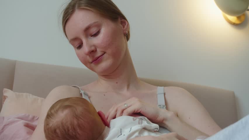 Mother breastfeeds newborn in close embrace, creating timeless image of maternal devotion. Symbolic reading links nourishment with protection, intimacy, and profound bond between two lives.