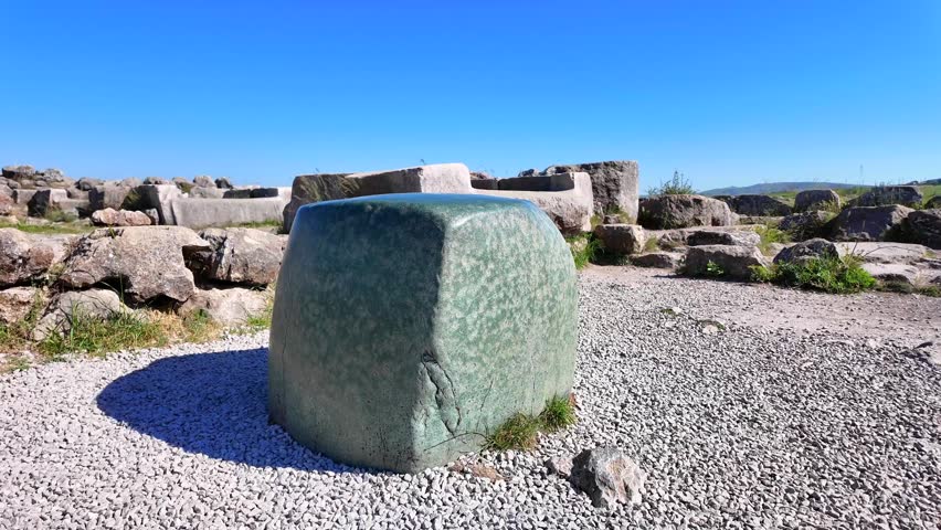 The famous smooth green nephrite stone block stands amid the ancient ruins of the Great Temple at Hattusa, Turkey.