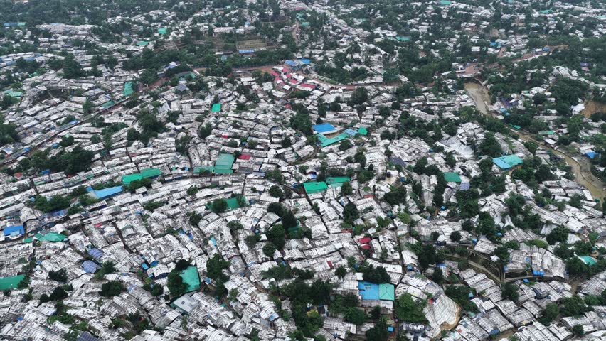 Aerial view of the dense Kutupalong Rohingya Camp featuring numerous makeshift shelters with tarpaulin roofs and narrow pathways in Cox