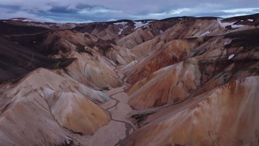 Aerial view of Landmannalaugar with colorful rhyolite mountains and a winding riverbed in Rangarthing ytra, Iceland.