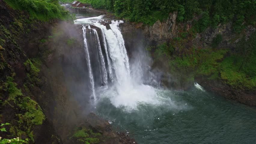 Snoqualmie Falls drops into the Snoqualmie River canyon amid lush evergreen forest and rising mist in Washington State, USA. 4K UHD video.