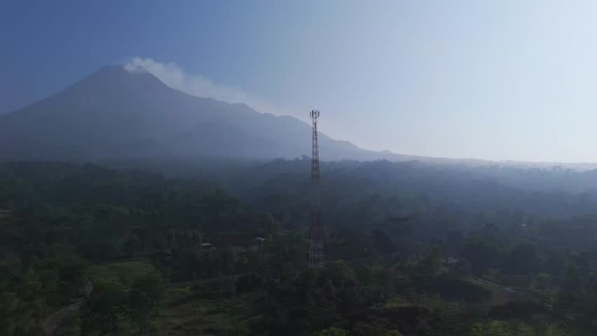 Aerial view of a telecommunications tower standing before the volcanic Mount Merapi in Kecamatan Pakem, Daerah Istimewa Yogya, Indonesia.