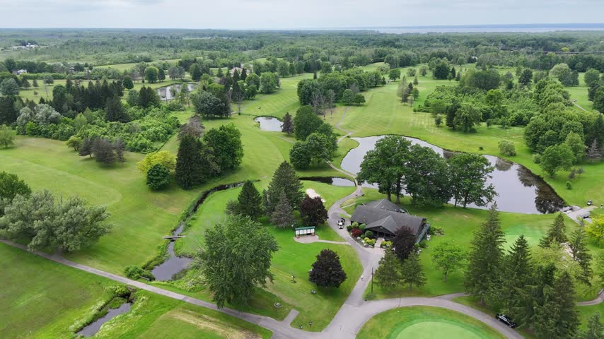 Open fields spanning across the landscape interspersed with trees and fairways.