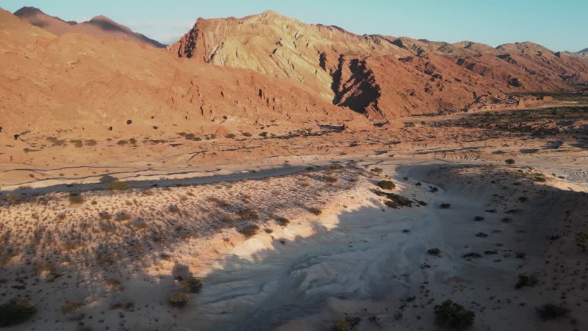 Aerial view of the arid Valles Calchaquies landscape with rugged mountains and desert terrain in San Carlos, Salta, Argentina.