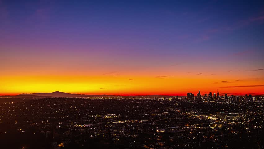 View of the Los Angeles skyline at sunset with vibrant orange and purple sky over the urban landscape in Los Angeles, California, United States.