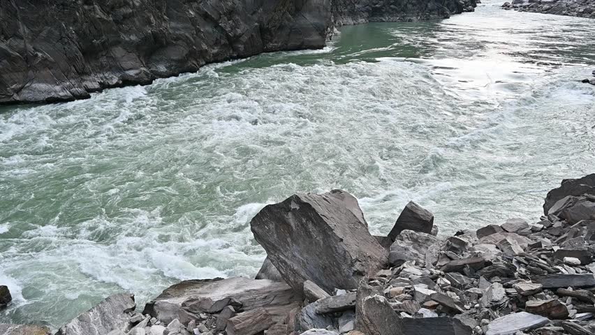Yangtze river flowing through the narrow landscape of Tiger Leaping Gorge in Yunnan province of China. Scenic spot where a tiger is said to have leaped across the river, thus giving the gorge its name.