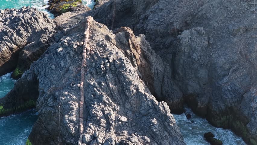 Aerial view of La Palma rocks and crashing Pacific waves in Cabo San Lucas.